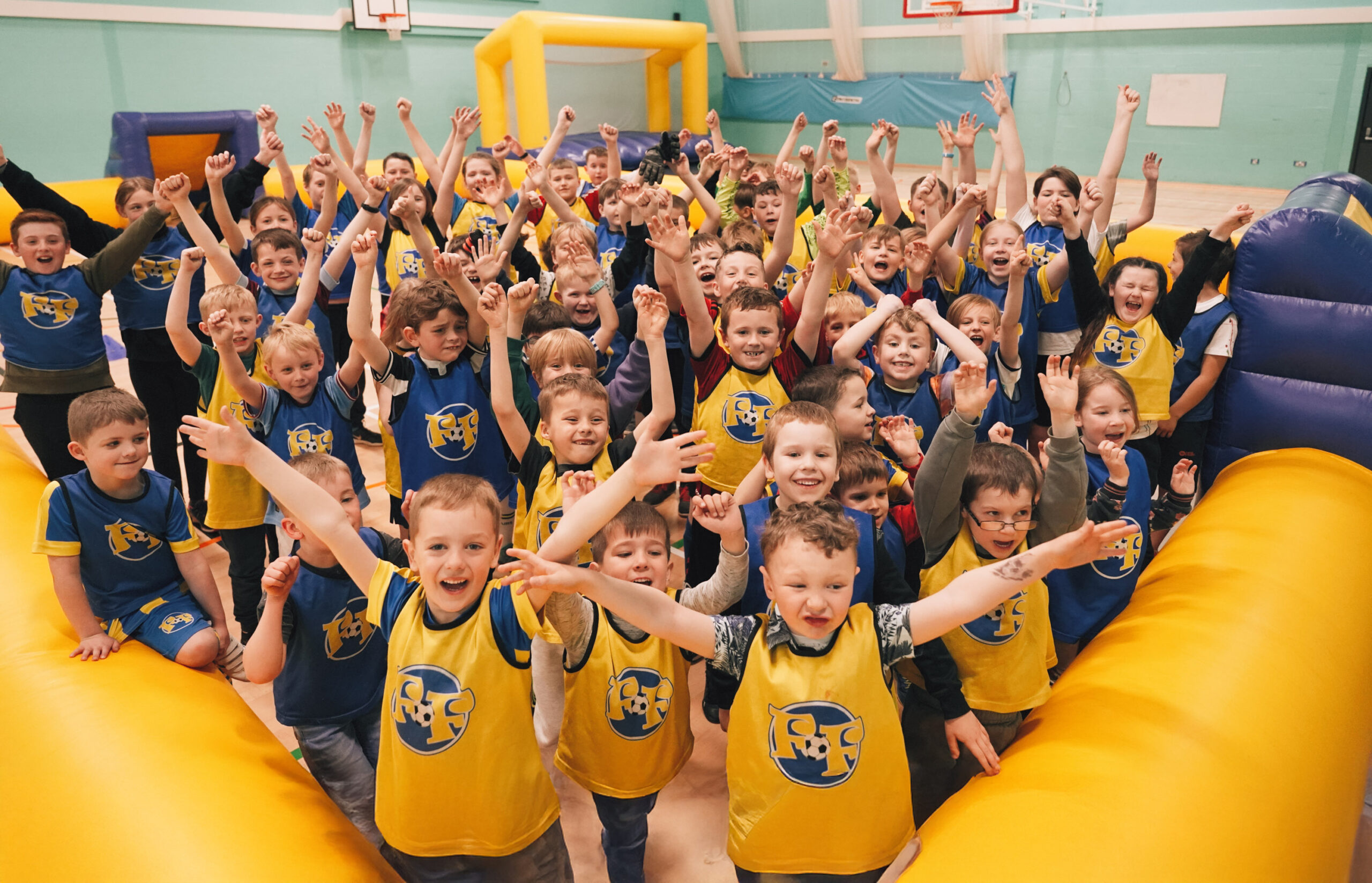 Children cheering in front of the camera at a Football Fun Factory camp